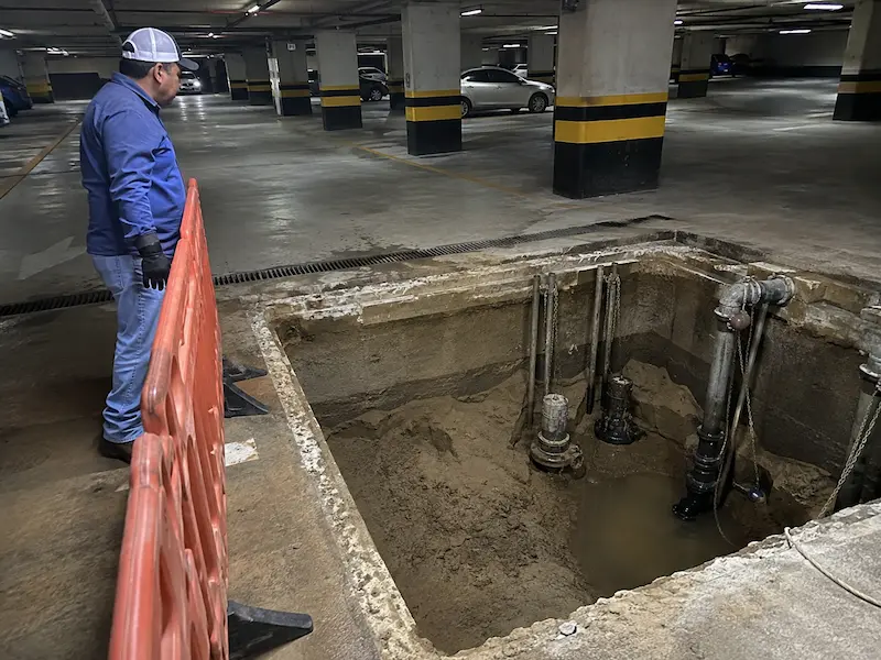 Cárcamo pluvial azolvado en el sótano de un estacionamiento antes del retiro de arena y sedimento